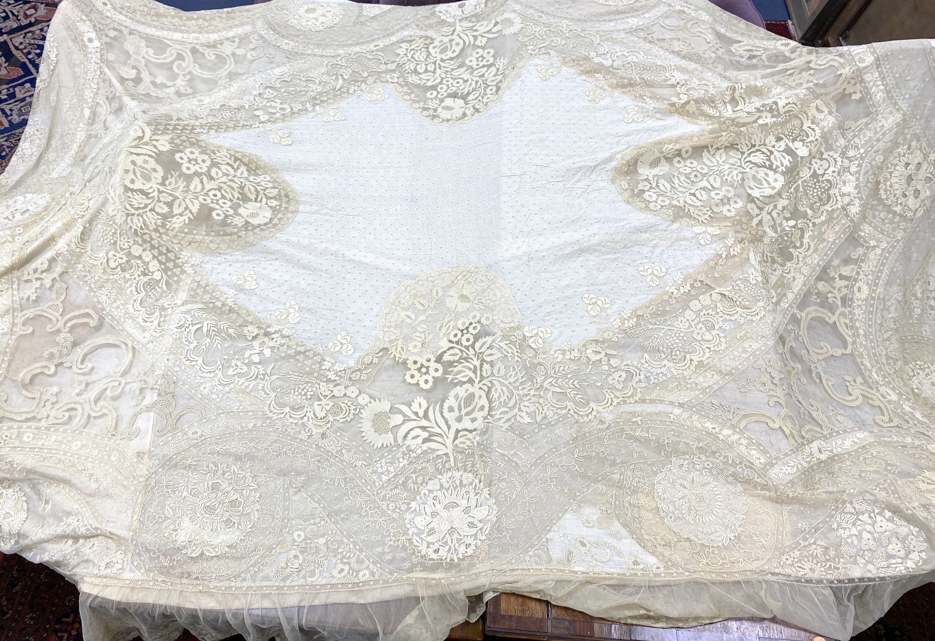 An Edwardian hand made lace bedspread. Hand sewn using finely spun lawn, decorated with Carrickmacross and white work embroidery, edged in bobbin lace. Possibly made as part of a trousseau.